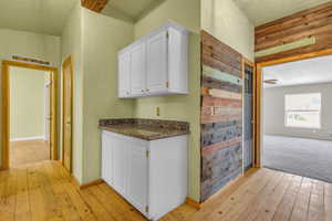 Bar featuring light colored carpet and white cabinetry