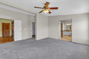 Unfurnished bedroom with light hardwood / wood-style floors, ensuite bath, ceiling fan, and lofted ceiling