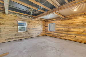 Spare room with concrete flooring and wood walls