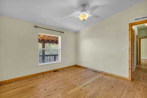 Empty room with ceiling fan and light hardwood / wood-style flooring