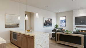 Bar featuring light stone countertops, a large fireplace, light wood-type flooring, and pendant lighting