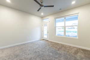 Carpeted spare room featuring ceiling fan