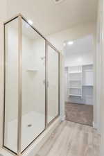 Bathroom with walk in shower and hardwood / wood-style floors