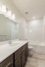 Full bathroom featuring toilet, bathtub / shower combination, hardwood / wood-style floors, and vanity