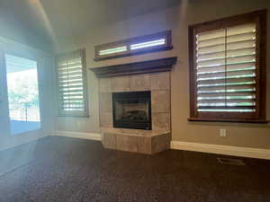 Primary bedroom with a tiled fireplace and carpet floors with access to covered deck