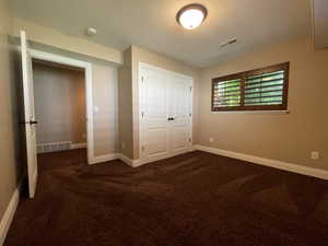 Bedroom featuring dark carpet and a closet with French doors