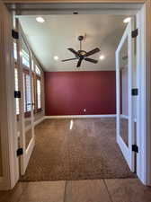 Carpeted office with ceiling fan, vaulted ceiling, and French doors