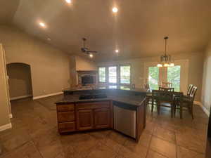 Kitchen featuring tile floors, sink, vaulted ceiling, and stainless steel dishwasher