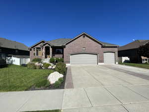 Single story home featuring a garage and a front yard