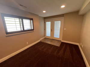 Carpeted entryway featuring basement walkout