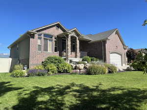 View of front of home with a garage and a front lawn