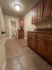 Laundry Room with tile counters, tile floors, and a textured ceiling