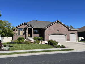 View of front of home with a garage and a front lawn