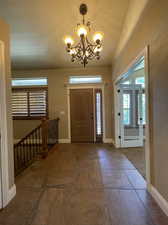 Entrance foyer with a notable chandelier and tile flooring