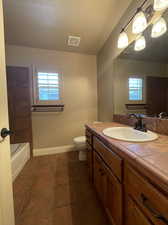 Full bathroom featuring tile flooring, plenty of natural light, vanity, and toilet