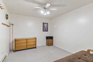 Bedroom featuring carpet flooring, baseboard heating, and ceiling fan