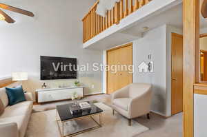 Living room with a high ceiling, ceiling fan, and carpet floors