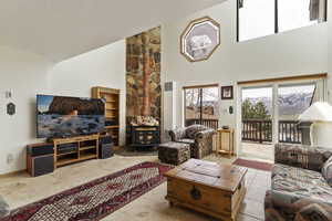 Living room with a towering ceiling, a textured ceiling, and tile flooring