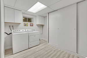 Laundry room featuring independent washer and dryer, washer hookup, and cabinets