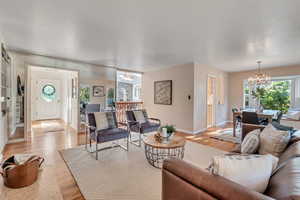 Living room featuring light hardwood / wood-style floors, a healthy amount of sunlight, and a chandelier