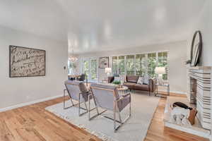 Living room featuring a notable chandelier, light wood-type flooring, and a fireplace