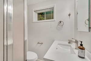 Bathroom featuring a textured ceiling, toilet, and vanity