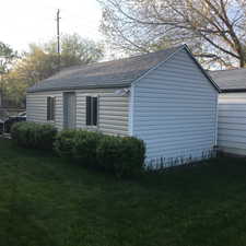 View of property exterior featuring a lawn