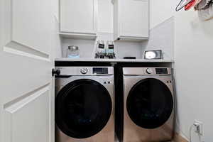 Laundry room with cabinets and washing machine and clothes dryer