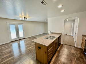 Kitchen with black dishwasher, sink, and dark hardwood / wood-style floors