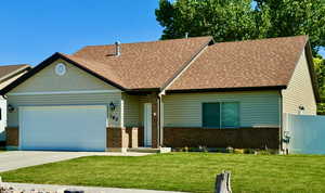 View of front of property featuring a garage and a front lawn