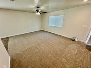 Carpeted spare room featuring ceiling fan