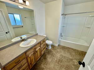 Full bathroom featuring tile floors, washtub / shower combination, vanity with extensive cabinet space, and toilet