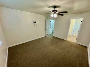 Spare room with carpet, ceiling fan, and a textured ceiling