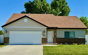 View of front of house with a garage and a front lawn