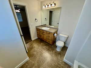 Bathroom with tile flooring, large vanity, ceiling fan, and toilet