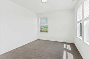 Empty room with dark carpet and a wealth of natural light