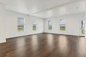 Interior space featuring beamed ceiling and dark wood-type flooring