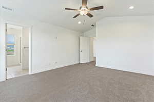 Carpeted spare room with lofted ceiling and ceiling fan