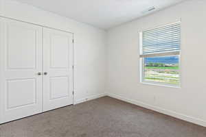 Unfurnished bedroom with a closet and carpet