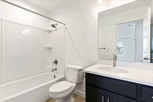 Full bathroom with vanity, toilet, and  shower combination