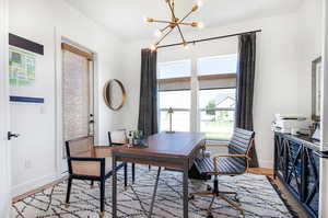 Office area featuring a notable chandelier and light wood-type flooring