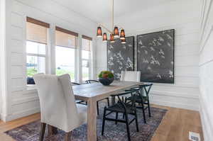 Dining space with an inviting chandelier and hardwood / wood-style floors