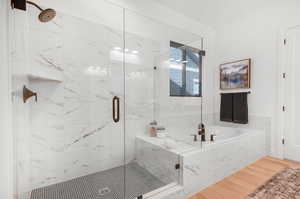 Bathroom featuring independent shower and bath and wood-type flooring