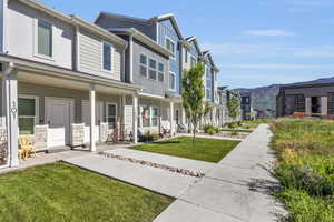 View of property exterior with a lawn and a porch