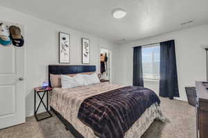 Carpeted bedroom featuring a textured ceiling