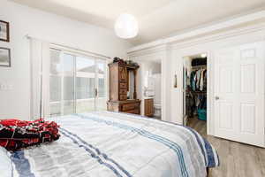 Bedroom with a closet, hardwood / wood-style floors, ensuite bath, and a spacious closet