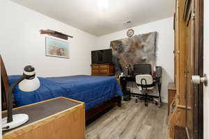 Bedroom featuring a textured ceiling and light hardwood / wood-style flooring