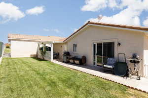 Back of property featuring a patio area and a lawn