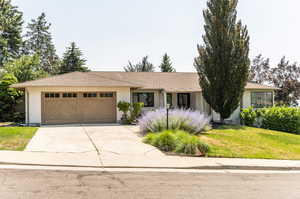 Single story home with a garage and a front yard