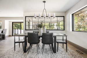 Dining space with wood-type flooring and an inviting chandelier